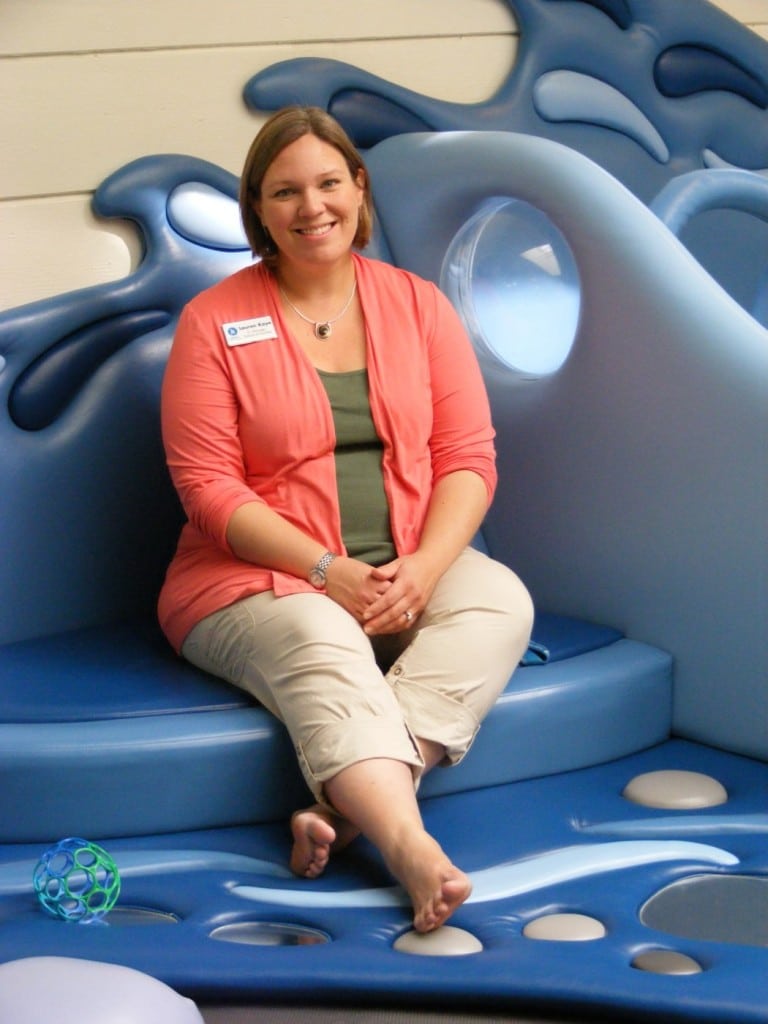 Kidspace Senior Manager of Exhibits & Facilities Lauren Kaye perches on the Shiny Stream in teh S. Mark Taper Foundation Early Childhood Learning Center, her favorite part of the museum.