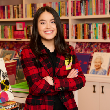 Teen Annabelle Change in red-and-black flannel shirt stands with her arms crossed in front of books inside her bookstore in Studio City.