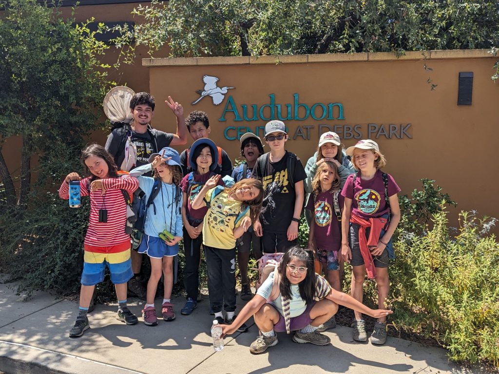A group of young kids part of the HAWKs program pose for a picture.