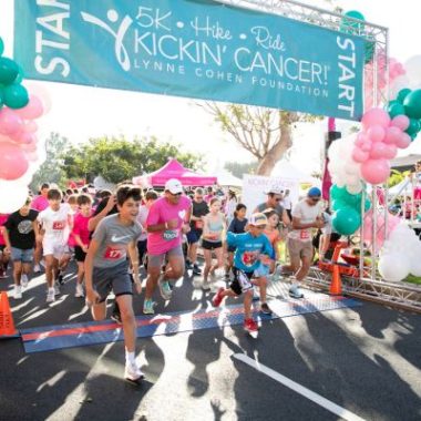 Runners of all ages take off from the starting line at the Kickin’ Cancer 5K, organized by the Lynne Cohen Foundation in Brentwood, Los Angeles, with balloons and banners marking the community event.