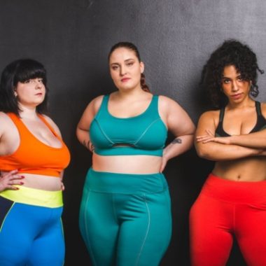 Three women of various body sizes are dressed in workout clothing.