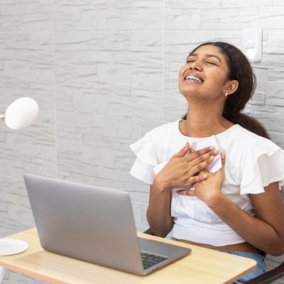 Student in front of a laptop looking like she just received distressing news.